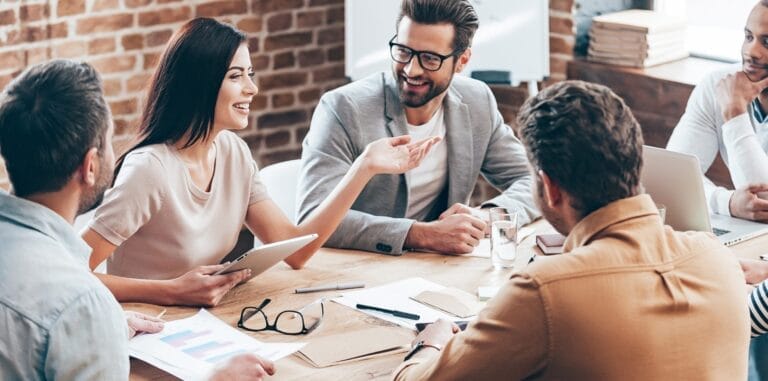 A group of employees sitting in a meeting and interacting